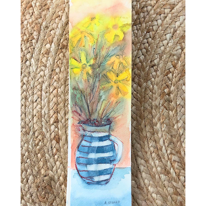 A blue and white Cornish vase holds an array of soft greenery and yellow open flowers on an orange background